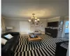 Carpeted living room featuring ornamental molding and a chandelier