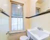 Bathroom featuring tile walls, sink, and toilet