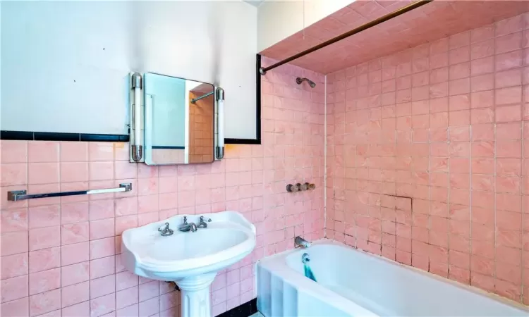 Bathroom featuring tile walls and tiled shower / bath combo