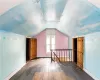 Bonus room with lofted ceiling and dark wood-type flooring