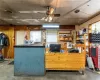 Kitchen featuring concrete flooring, wooden walls, and ceiling fan