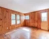 Unfurnished room with wood walls, plenty of natural light, and light hardwood / wood-style floors