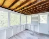 Unfurnished sunroom featuring wood ceiling, beamed ceiling, and plenty of natural light