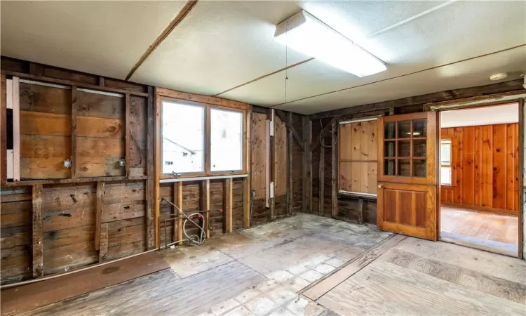 Miscellaneous room featuring a textured ceiling, wooden walls, and hardwood / wood-style flooring