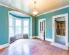 Spare room with radiator heating unit, hardwood / wood-style floors, and crown molding