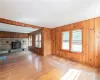 Unfurnished living room featuring wooden walls, light wood-type flooring, and a wood stove