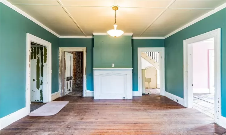 Unfurnished living room featuring ornamental molding and hardwood / wood-style flooring