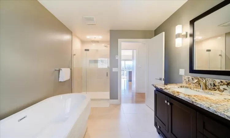 Kitchen with stainless steel appliances, range hood, backsplash, pendant lighting, and a kitchen island.