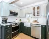 Kitchen with stainless steel appliances, light wood flooring,