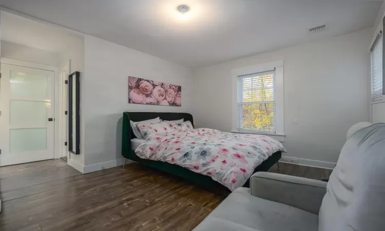 Bedroom with dark hardwood / wood-style floors