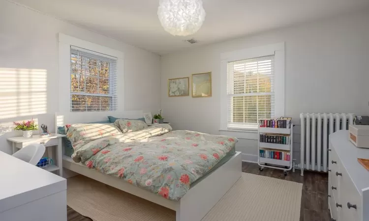 Bedroom with dark wood-type flooring and radiator