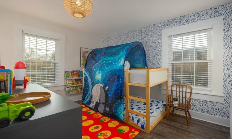 Bedroom featuring dark wood-type flooring and multiple windows