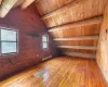 Empty room with baseboard heating, vaulted ceiling with beams, and wooden ceiling