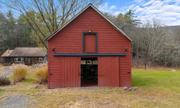 View of outbuilding featuring a lawn