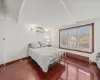 Bedroom with baseboard heating, a wall mounted AC, and hardwood / wood-style flooring