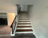 Stairs featuring hardwood / wood-style floors and washing machine and dryer