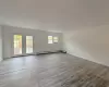 Spare room featuring french doors, light hardwood / wood-style floors, and a baseboard heating unit