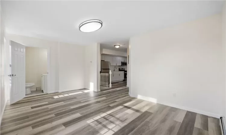 living room- 2nd floor unit w/ a view of hallway 1/2 bath and entrance to kitchen