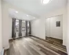 living room w/ dark wood-style flooring, large window offering natural light- 1st floor unit