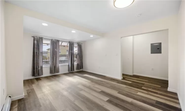 living room w/ dark wood-style flooring, large window offering natural light- 1st floor unit