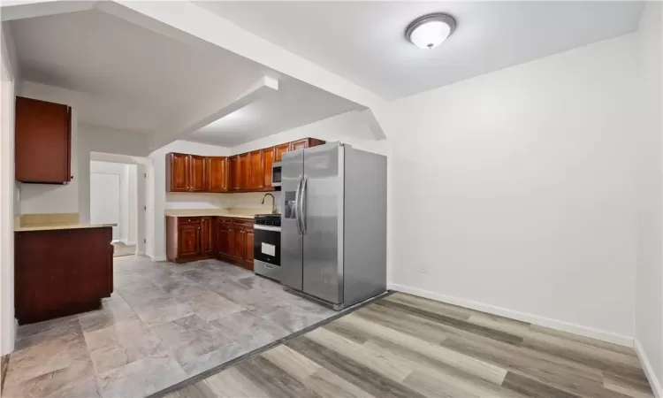 kitchen w/ stainless steel appliances and floor tiles, 1st floor unit