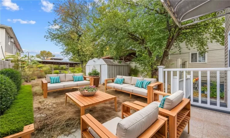 virtually staged backyard, featuring a shed, a patio, and an outdoor hangout area