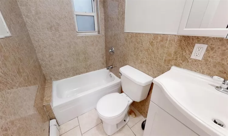 Full bathroom with vanity,  shower combination, tile patterned flooring, toilet, and tile walls