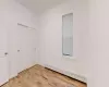 Unfurnished bedroom with a baseboard radiator, a closet, and light hardwood / wood-style floors