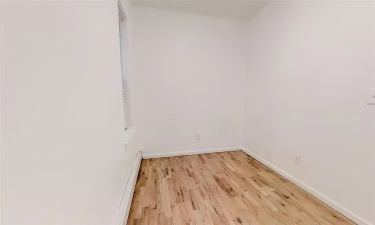 Spare room featuring hardwood / wood-style flooring and a baseboard radiator