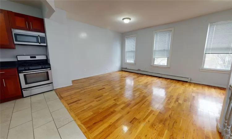 Kitchen featuring stainless steel appliances, light wood-type flooring, and a baseboard heating unit