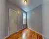 Spare room featuring wood-type flooring, baseboard heating, and vaulted ceiling