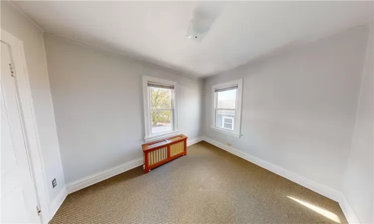 Unfurnished room with radiator heating unit, carpet, and ornamental molding