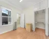 Unfurnished bedroom featuring light hardwood / wood-style floors, vaulted ceiling, radiator, and a closet