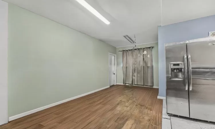 Kitchen with stainless steel fridge with ice dispenser and light hardwood / wood-style floors