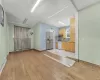 Kitchen featuring tasteful backsplash, light hardwood / wood-style flooring, a baseboard heating unit, stainless steel fridge, and white dishwasher