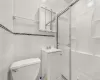 Bathroom featuring vanity, toilet, tile walls, and walk in shower