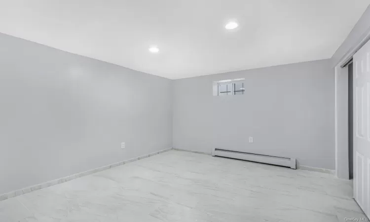 Empty room featuring baseboard heating