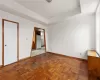 Unfurnished bedroom featuring parquet floors and white fridge