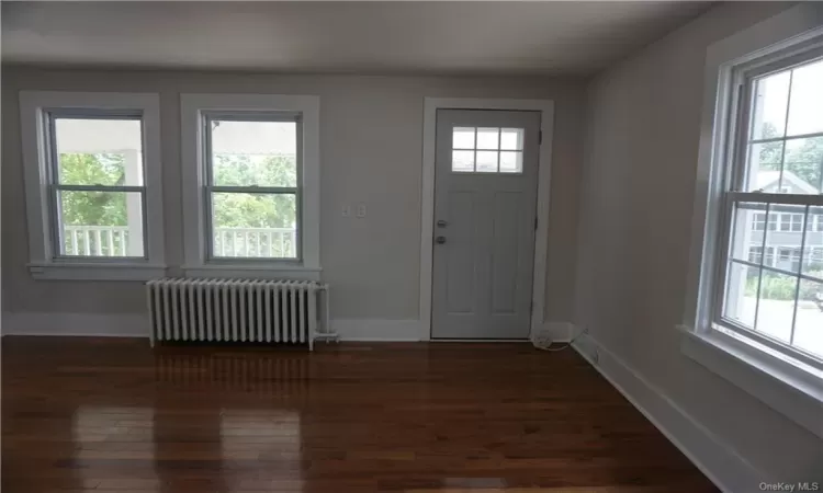 Entryway with dark hardwood / wood-style floors and radiator