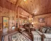 Living room featuring wood-type flooring, wooden ceiling, lofted ceiling with beams, and wooden walls