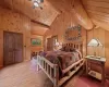 Bedroom with vaulted ceiling with beams, wood ceiling, wood walls, ceiling fan, and wood-type flooring