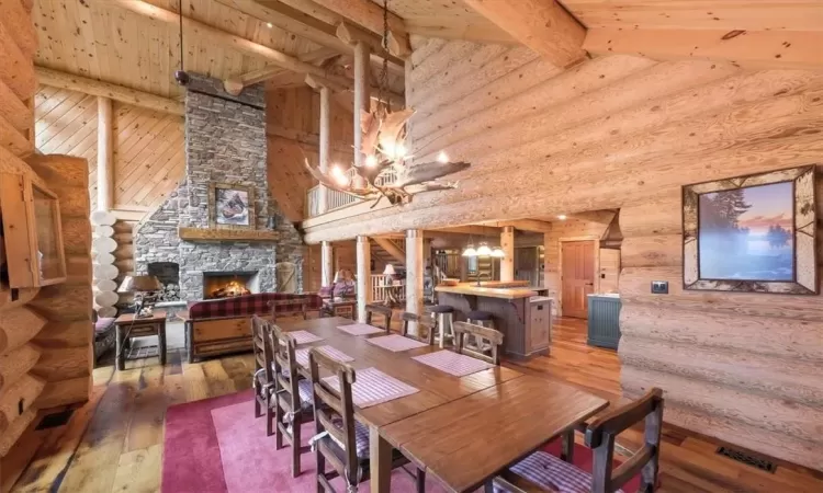 Dining room featuring beam ceiling, hardwood / wood-style floors, and rustic walls