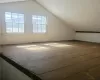 Bonus room featuring a wealth of natural light, hardwood / wood-style flooring, and lofted ceiling