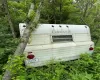 Camper to be removed unless the buyer wishes to keep it- it is in rough shape but might be used for shelter if cleaned and fixed up a bit.