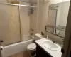 Full bathroom featuring vanity, toilet, and bath / shower combo with glass door