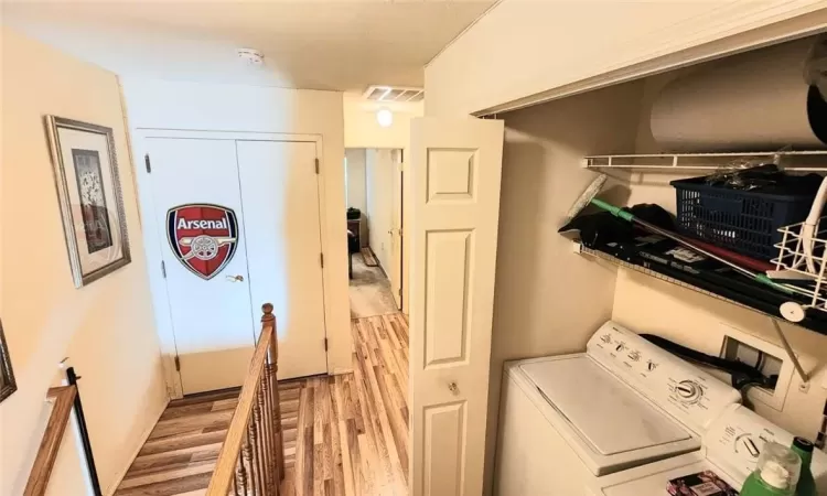 Washroom with separate washer and dryer, hookup for a washing machine, and light hardwood / wood-style flooring