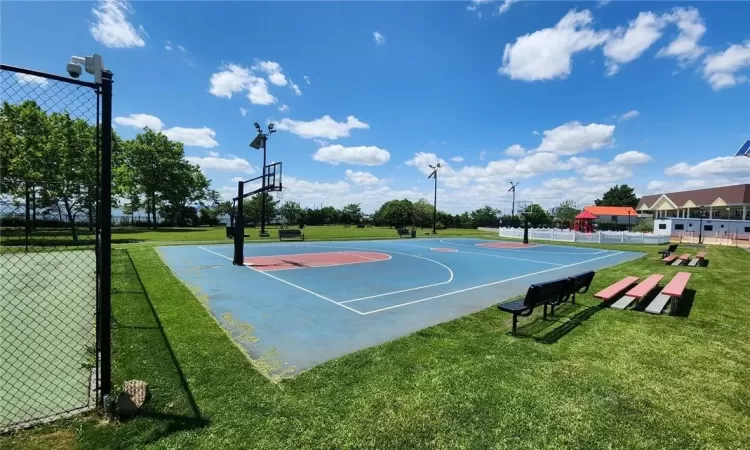 View of basketball court with a lawn