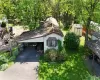 View of front facade featuring a carport, a front lawn, and a storage shed