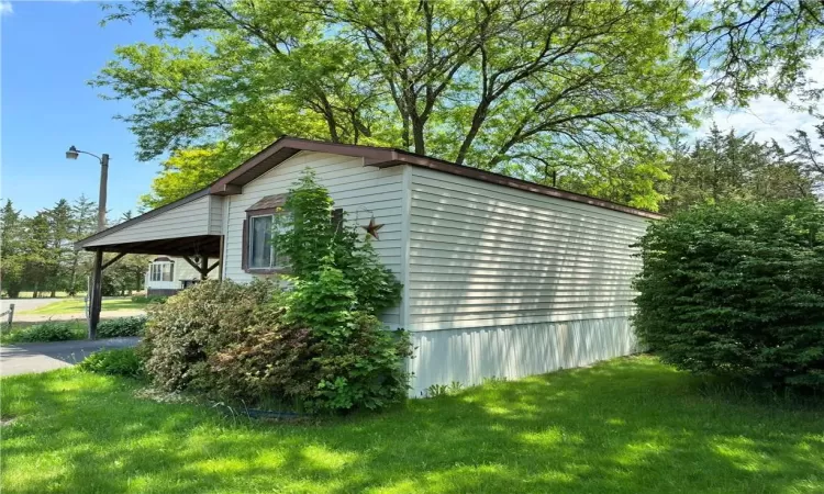 View of property exterior featuring a lawn