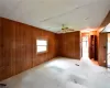 Empty room featuring ceiling fan and wood walls